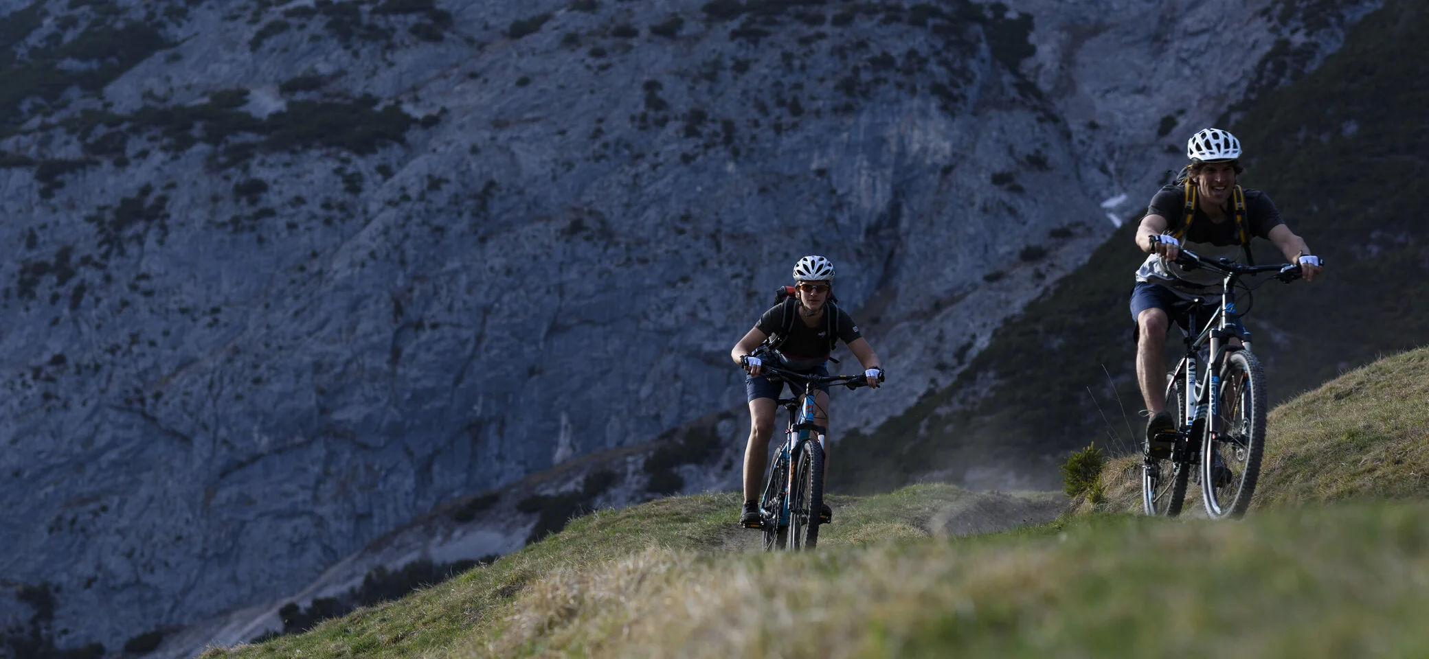 Zwei Mountainbiker fahren einen Trail in den Bergen hoch. | © DAV/Wolfgang Ehn